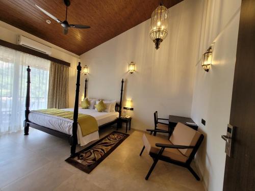 a bedroom with a bed and a chair at Mastiff Grand La Villae in Lonavala