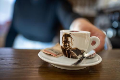 a cup of coffee on a plate on a table at Albergo Ad Astra in Pescasseroli