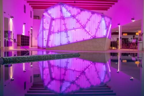 a room with a pool with purple lighting at Narzissen Vital Resort Bad Aussee in Bad Aussee