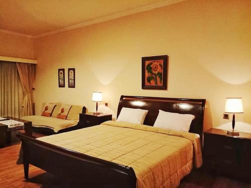 um quarto de hotel com uma cama e um quarto com duas lâmpadas em Kulem Cisitu em Bandung