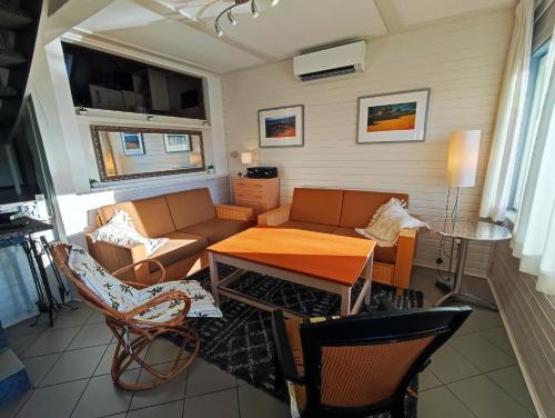 ein Wohnzimmer mit einem Sofa, einem Tisch und Stühlen in der Unterkunft Ferienhaus Seeblick KIR100 in Kirchheim