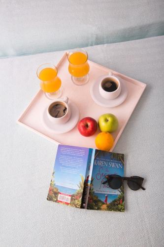 a pink tray with two cups of orange juice and fruit at Kalypso Studios in Myrties