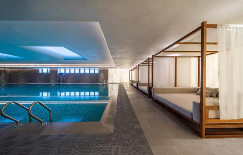 西安市にあるHUALUXE Xi'an Chanba by IHG-西安浐灞华邑酒店-Near Xi'an International Convention Exhibition Center and Shopping mall and The Romantic show of Xi'an-Free Luggage Storage-English Serviceのプール、ベッド、バスタブが備わるホテルルームです。