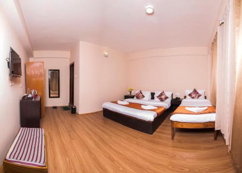 a room with two beds and a couch at Hotel Shambhala in Gangtok