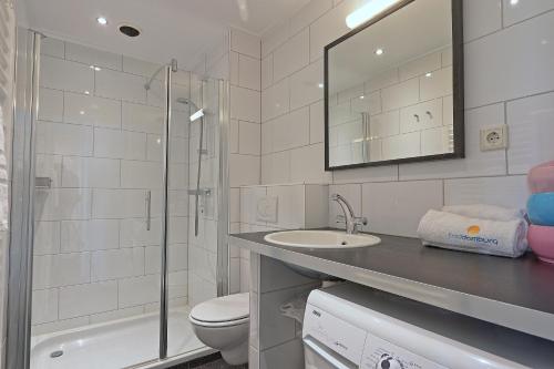 een badkamer met een toilet, een wastafel en een douche bij Residence de L'Europe - Baddomburg in Domburg