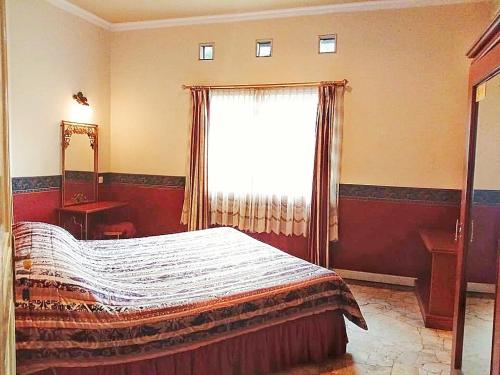 a bedroom with a bed and a large window at Kulem Cisitu in Bandung
