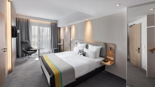 a hotel room with a large bed and a desk at Holiday Inn Express Munich - City East by IHG in Munich