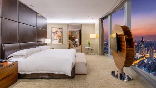 a bedroom with a large bed and a large window at InterContinental Nanjing by IHG in Nanjing
