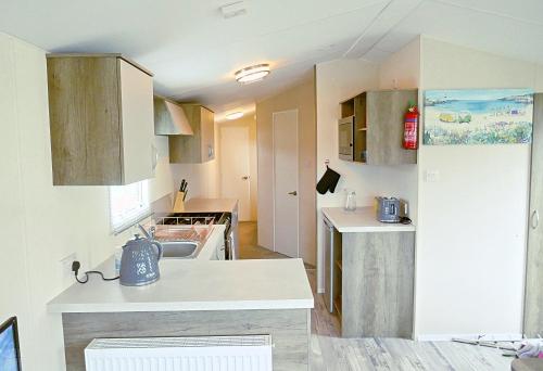 a small kitchen with a sink and a refrigerator at Plot 188D Lakeside Cabin, Wyldecrest, Millom in Millom
