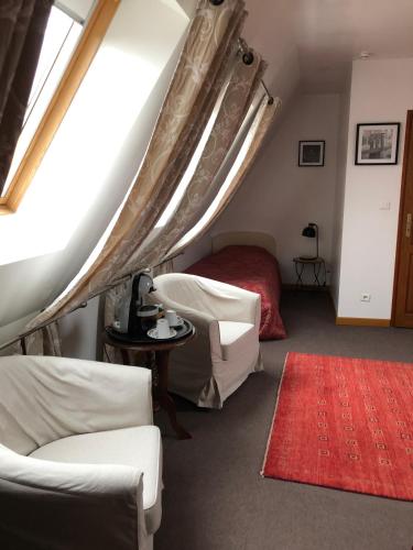 a bedroom with a bed and a red rug at La Ferme de la Place in Bouvines
