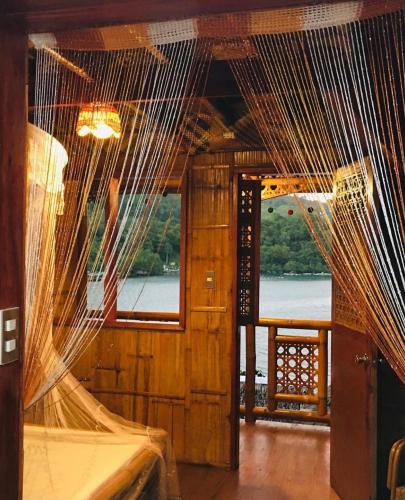 a bedroom with mosquito nets hanging from the ceiling at Camiguin Blue Lagoon Cottages in Mahinog