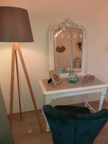 a dressing table with a mirror and a lamp at La Maison de Sidonie in Jalhay