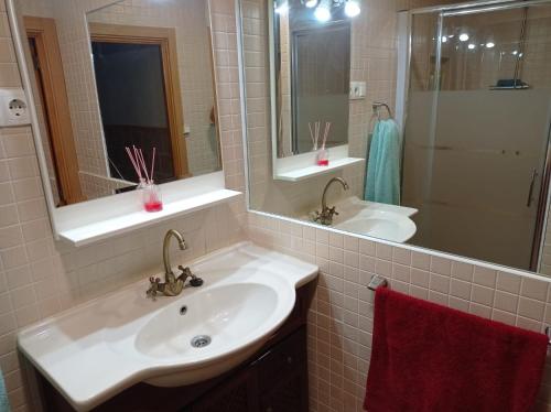 La salle de bains est pourvue de 2 lavabos et d'un miroir. dans l'établissement Casa rural khaleesi, à El Carpio de Tajo