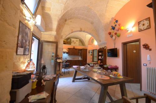 een keuken en eetkamer met een tafel in een kamer bij B&B Corte Dei Figuli in San Pietro in Lama