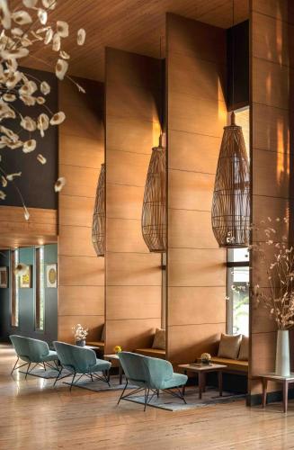 a lobby with chairs and tables and pendant lights at Vivanta Sikkim Pakyong in Gangtok