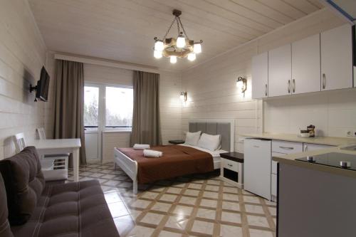 een kamer met een bed en een keuken met een bank bij Villa Medova in Kosiv