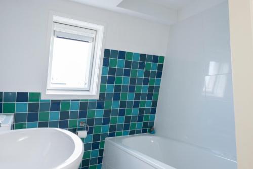 een badkamer met toilet, wastafel en raam bij Kustverhuur, Park Schoneveld, Zeester 27 in Breskens