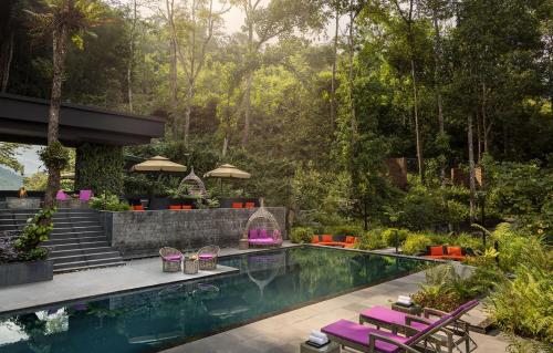 einen Pool mit lila Stühlen und ein Resort in der Unterkunft Vivanta Sikkim Pakyong in Gangtok