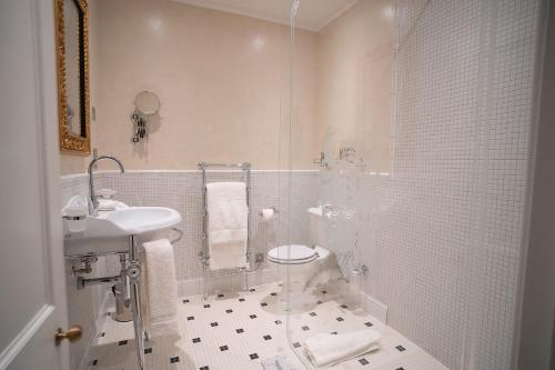 a white bathroom with a toilet and a sink at Thornbury Castle - A Relais & Chateaux Hotel in Thornbury