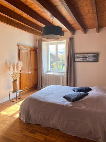 une chambre avec un grand lit et une fenêtre dans l'établissement Maisonbel, gite convivial Bretagne Vannes Sarzeau 15 personnes, à Surzur