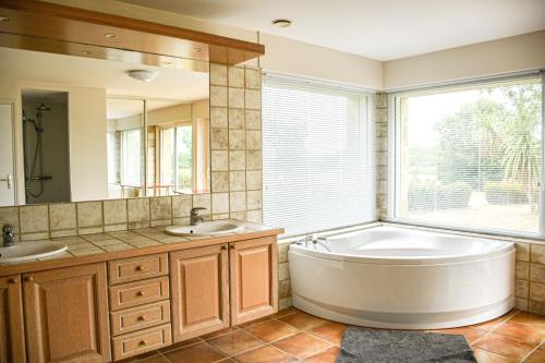 a bathroom with a tub and two sinks and a window at Maisonbel, gite convivial Bretagne Vannes Sarzeau 15 personnes in Surzur