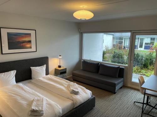 una camera con letto, divano e finestra di Hotel Nørrevang a Bøtø By