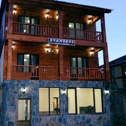 a large wooden building with a sign on it at Hotel Svanseti in Mestia