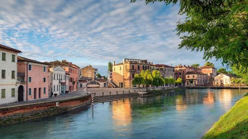 a river in a city with buildings next to it at Isola Di Caprera in Mira
