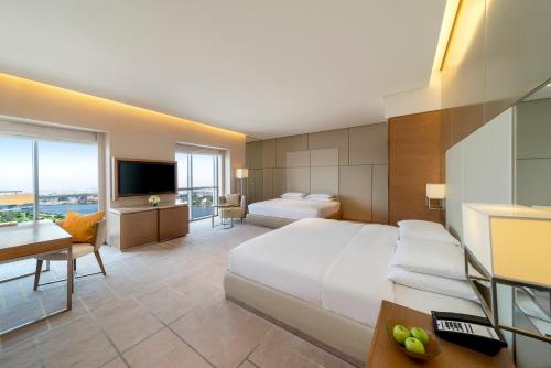 a hotel room with a large bed and a television at Hyatt Regency Dubai Creek Heights in Dubai