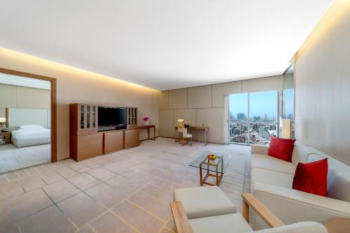 a living room filled with furniture and a tv at Hyatt Regency Dubai Creek Heights in Dubai