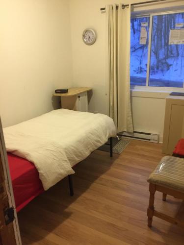 a small bedroom with a bed and a window at Chalet Ski Mont Calm Water Falls River Rawdon in Rawdon