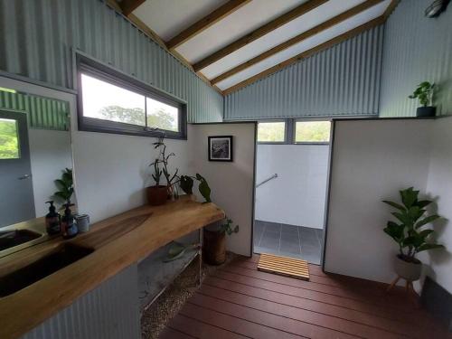 Habitación con cocina con fregadero y 2 ventanas. en Bellingen Guest Suite with Forest Views 