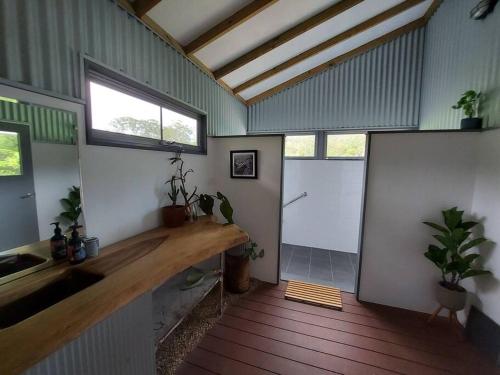 a room with a kitchen with a sink and two windows at Bellingen Guest Suite with Forest Views in Brierfield