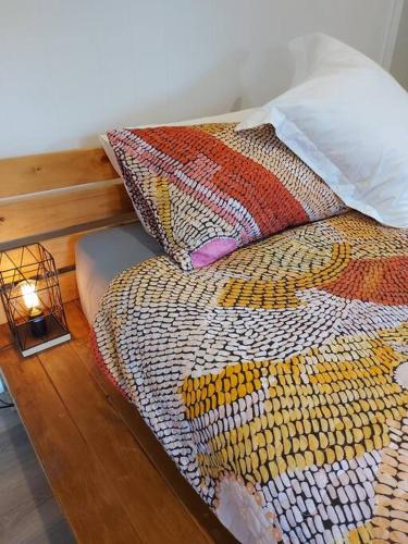 a bed with a colorful comforter and a lamp at Bellingen Guest Suite with Forest Views in Brierfield