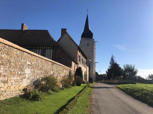 an old brick building with a tower and a street at LA MOTTE FÉODALE luxury medieval MANOR rated 5 stars in Normandy in Le Mesnil-Jourdain