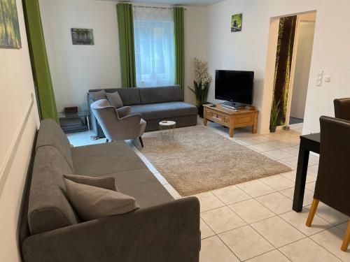 a living room with a couch and a television at Ferienwohnung im Herzen der Holledau in Pörnbach