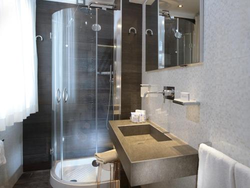 a bathroom with a glass shower and a sink at Hotel Santa Marina in Venice