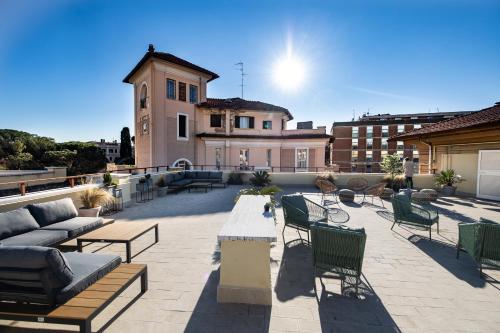 un patio con sillas y mesas y un edificio en The Cross Hotel en Roma