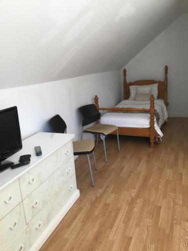 a bedroom with a bed and a dresser with a tv at Chalet Ski Mont Calm Water Falls River Rawdon in Rawdon