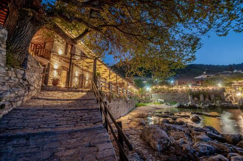 a building with a stone pathway next to a river at Cleopatra's Miramare in Damouchari