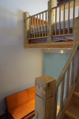 a loft room with an orange couch and a staircase at Jinan Mountain and Sea Culture Hotel in Jinan