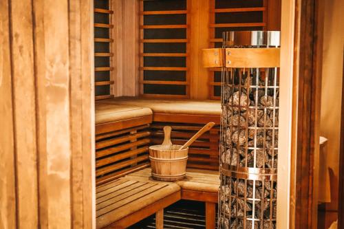a wooden sauna with a bucket and a utensil in it at Lydinge Resort in Hyllinge