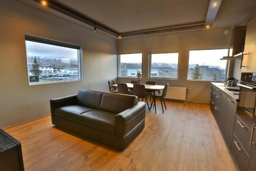 ein Wohnzimmer mit einem Ledersofa und einem Tisch in der Unterkunft Akureyri Luxury Apartments in Akureyri