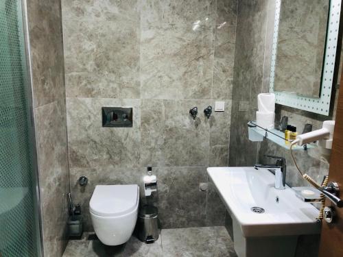 a bathroom with a toilet and a sink at Arti̇m Apart Hotel in Fethiye