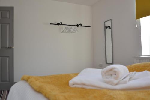 1 dormitorio con 1 cama con toallas y canasta de baloncesto en Modern 3 bed home, Sleeps 6, Free Netflix and WIFI, en Burnley