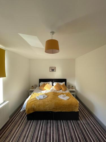バーンリーにあるModern 3 bed home, Free Parking, Free Netflix and WIFIのベッドとタオル2枚のある寝室
