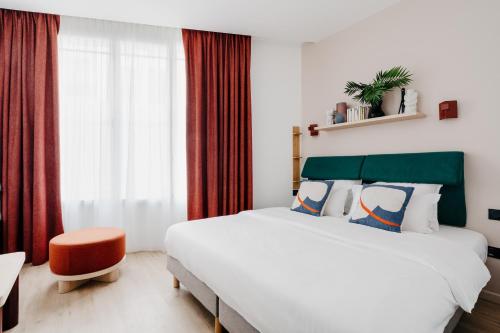 Un dormitorio con una cama grande y una ventana en Edgar Suites Auteuil - Le Marois, en París