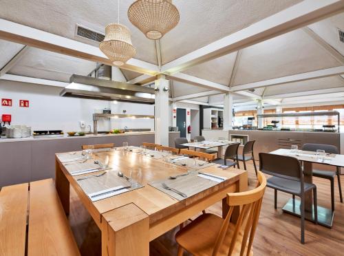 a dining room with a large wooden table and chairs at Globales Cala'n Bosch in Cala'n Bosch