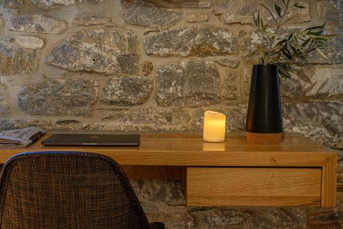 a desk with a candle and a laptop and a vase at Cleopatra's Miramare in Damouchari