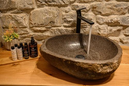 a stone sink with a faucet in a bathroom at Cleopatra's Miramare in Damouchari